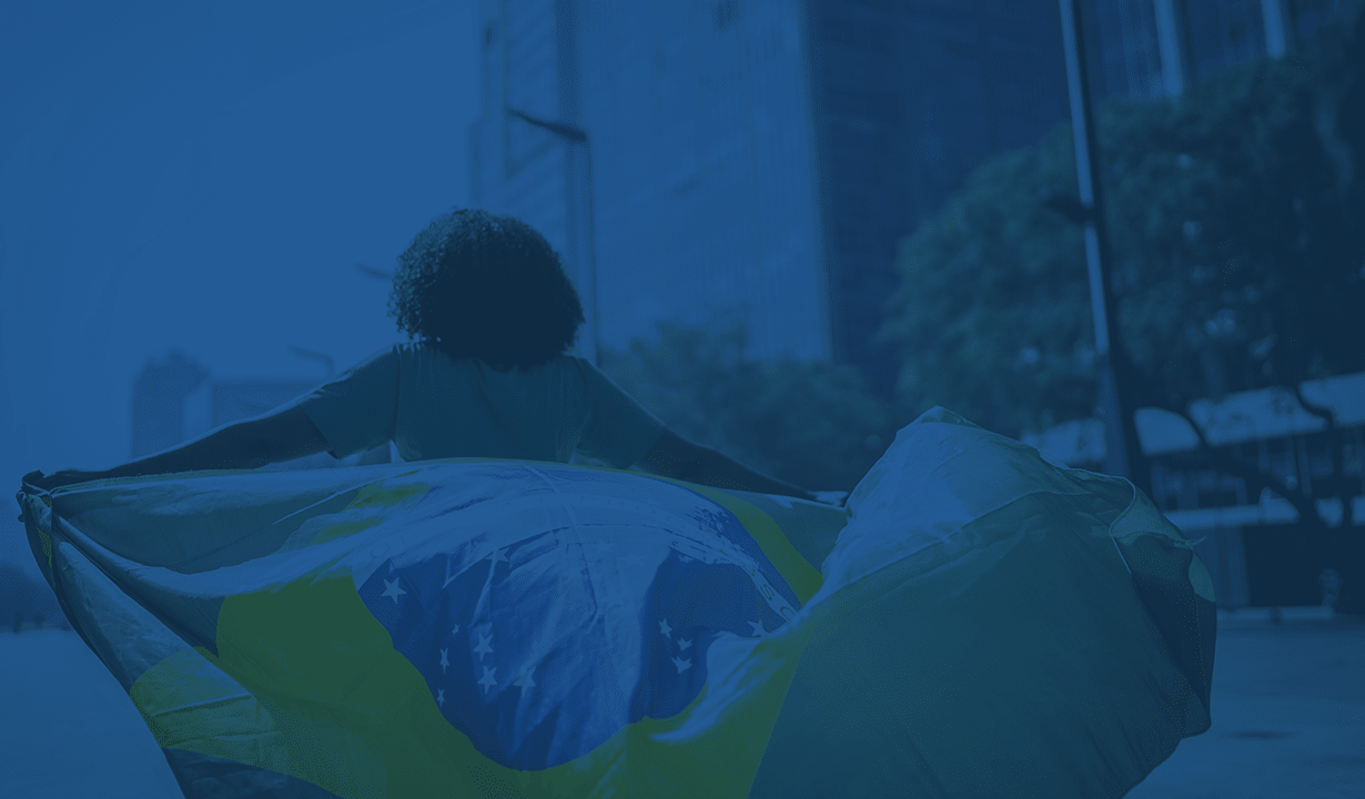 In a city backdrop, a woman displays a Brazilian flag