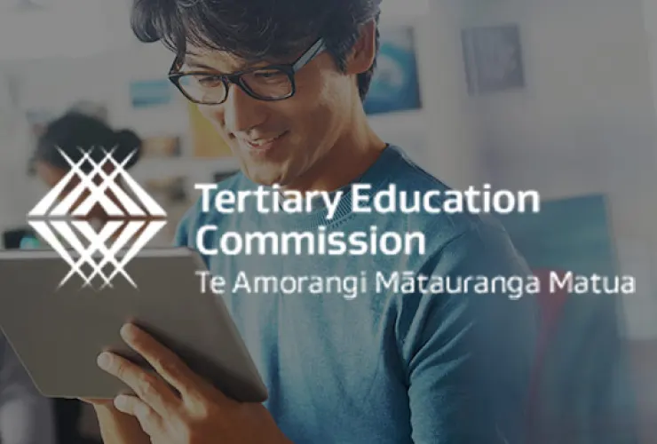 Person wearing glasses and a blue shirt holds a tablet, with text "Tertiary Education Commission Te Amorangi Mātauranga Matua" overlaid on the image.