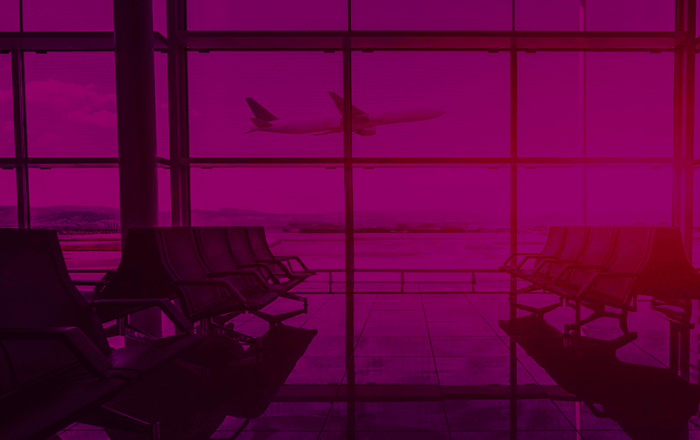 An airport terminal with empty seats, large windows, and a plane taking off in the background. The image is overlaid with a pink tint.