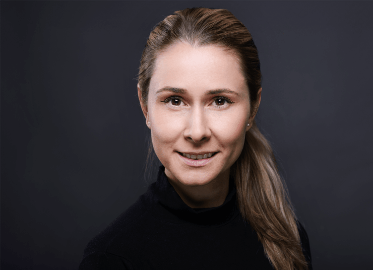 Headshot of Qlik AI Council member, Kelly Forbes. She has blonde hair pulled back into a ponytail, wearing a black top, and is smiling against a dark background.