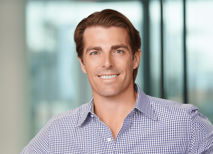 Headshot of Qlik Board of Directors member, Chip Virnig. He has light brown hair , is smiling at the camera, and wearing a checkered shirt. The background is out of focus.