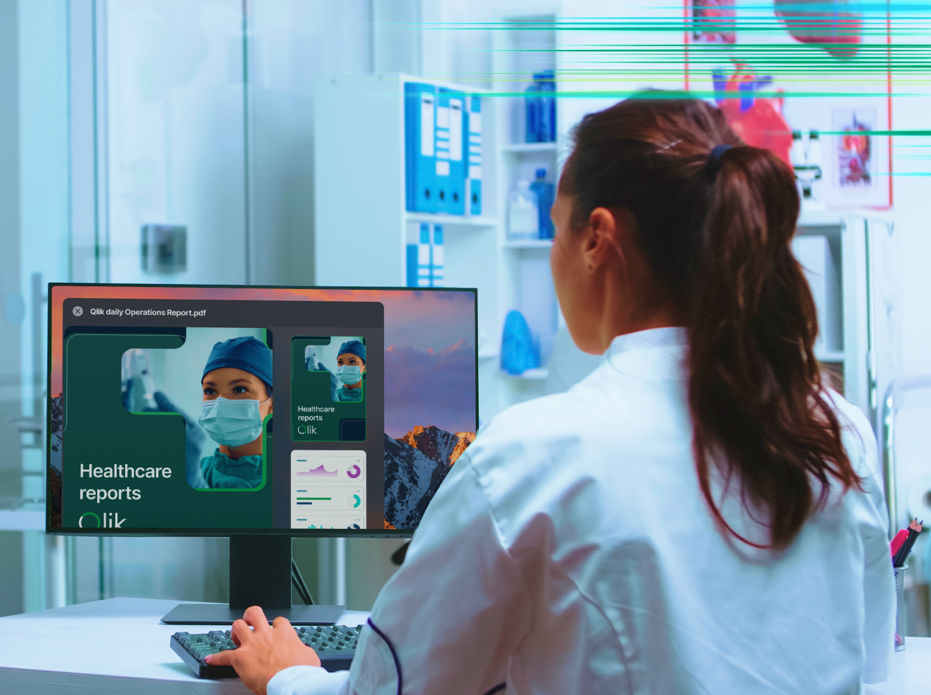 A woman in a white lab coat reviews healthcare reports on a computer screen.